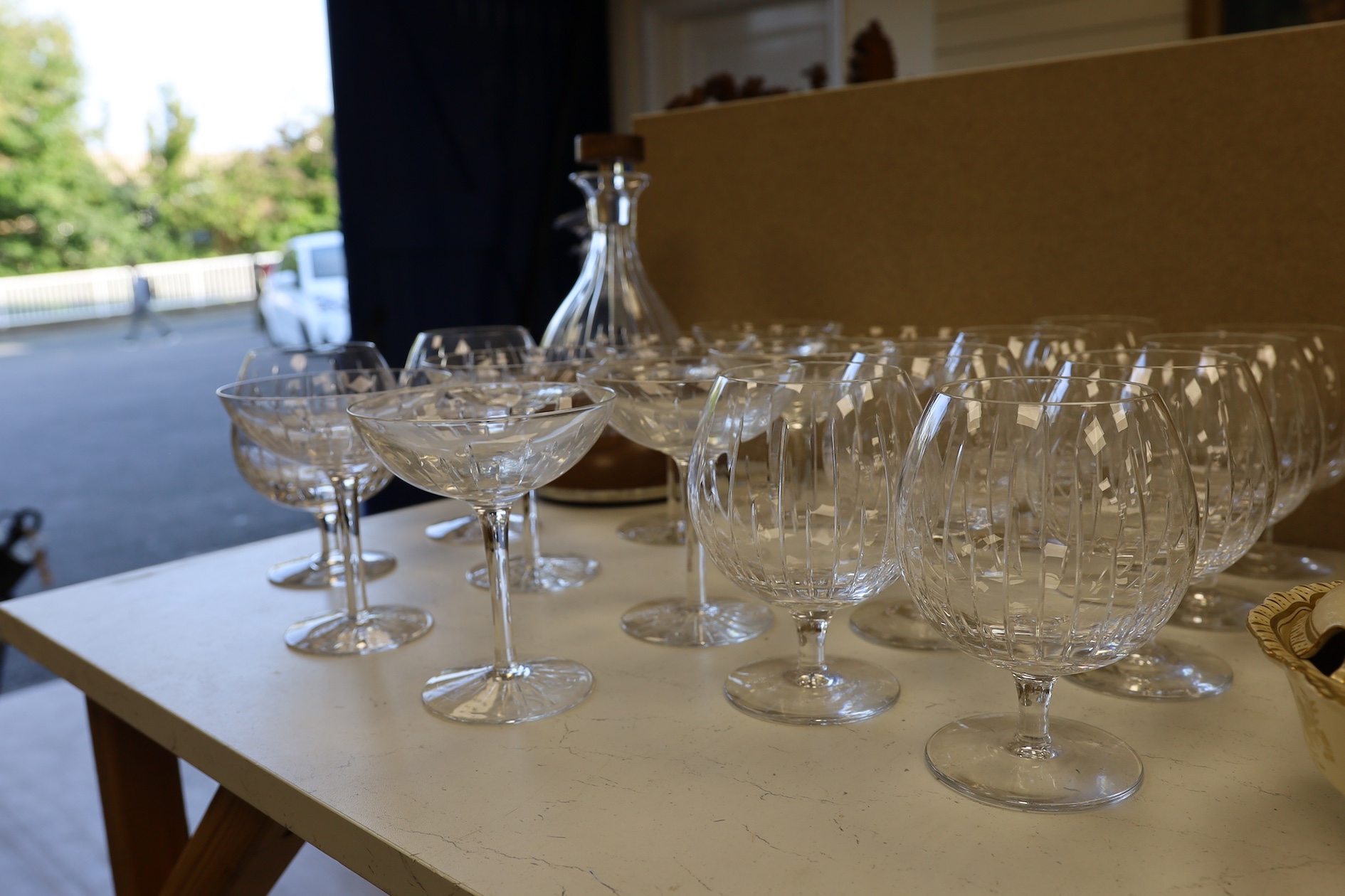 A Linley Glyndebourne pattern cut glass decanter with a silver mounted stopper, on a weighted wooden coaster stand, and a matching set of ten goblets, and eight champagne coupes, largest 30cm high. Condition - all in ver